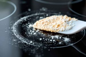 Votre plaque à induction est cramée ? Découvrez comment la nettoyer efficacement avec du bicarbonate de soude et une spatule en plastique pour un résultat impeccable